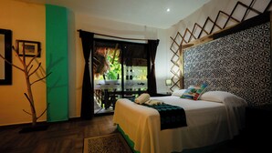 A hotel room with a bed, a view of the outdoors, a patterned wall, and a small plant. - Villas Tiburon Adults only (Isla Holbox)
