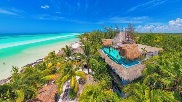 A tropical resort with a pool, thatched-roof structures, and a beach view. - Villas Tiburon Adults only (Isla Holbox)