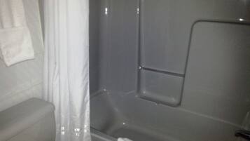 A bathroom with a bathtub, a toilet, and a shower curtain.