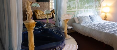 A bedroom with a bed, a bathtub, a statue, and a mural.