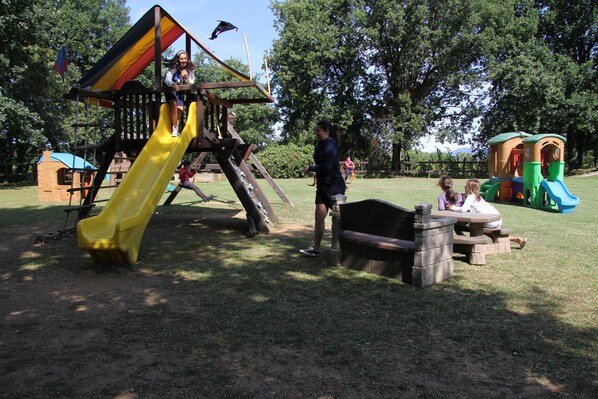 A playground with a slide, climbing structures, and picnic tables. - Antico Casale (Sarzana)