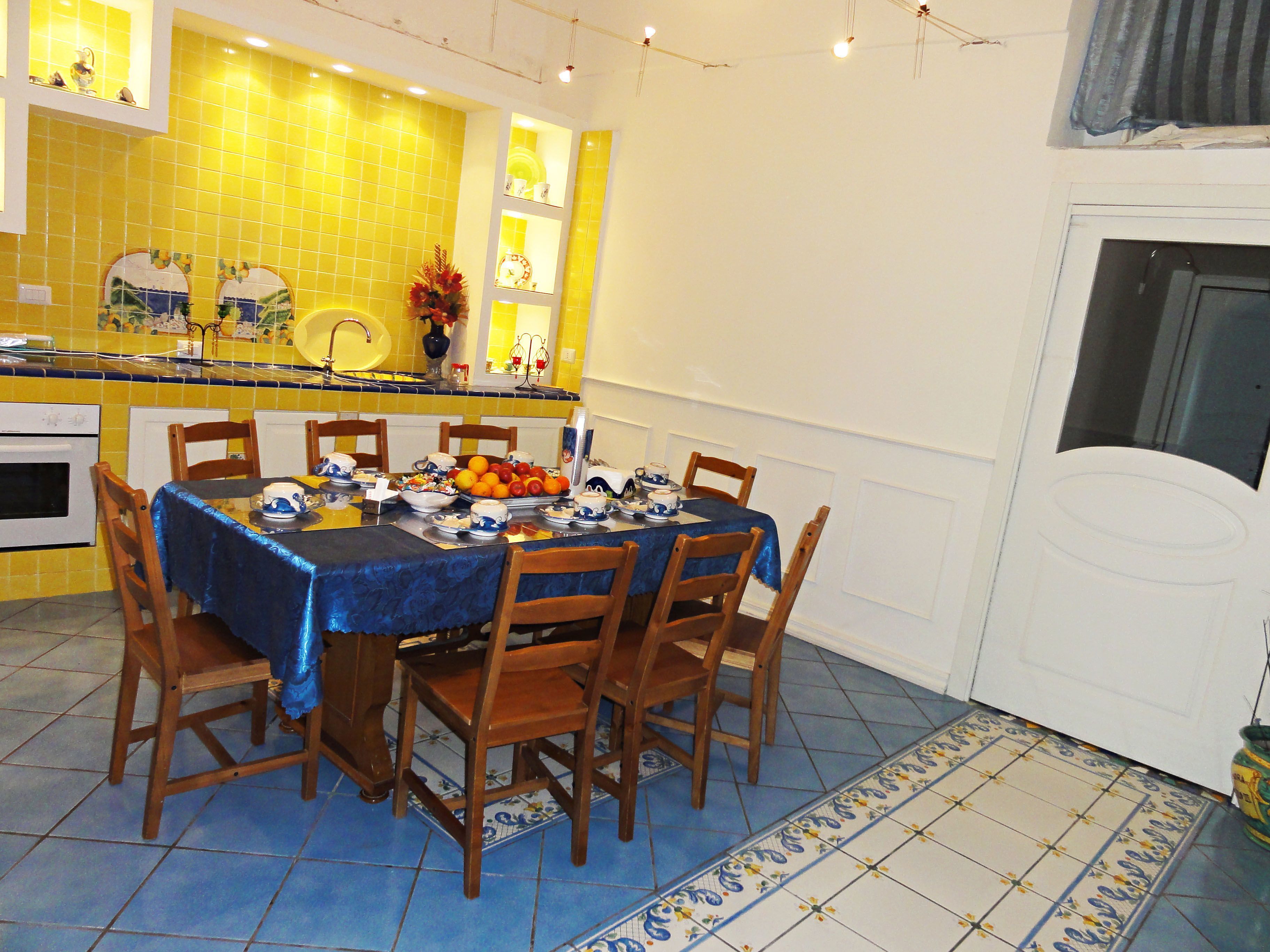 Un coin repas avec une table dressée pour six personnes, entourée de chaises en bois.