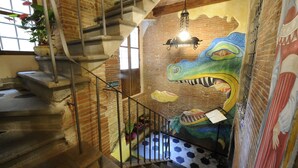 A staircase with a mural of a crocodile and a person. - Antica Corte dei Principi (Lucca)
