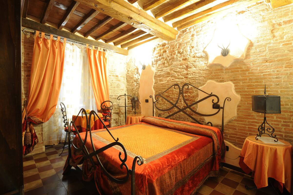 A room with a bed, a table, and a lamp.