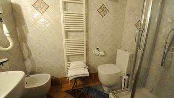 A bathroom with a toilet, bidet, and shower.