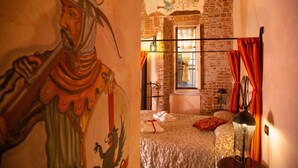 A room with a bed, a window with curtains, a wall mural, and a lamp. - Antica Corte dei Principi (Lucca)