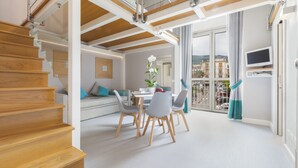 Een modern interieur met een trap, een eetgedeelte en een balkon met uitzicht over de stad.