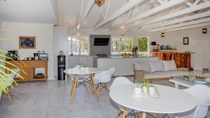 A spacious living area with a kitchen, dining table, and seating. - Brenton Beach House (Knysna)