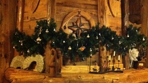 A stone fireplace with a Christmas tree and ornaments. - Hotel Mon Reve (Valtournenche)