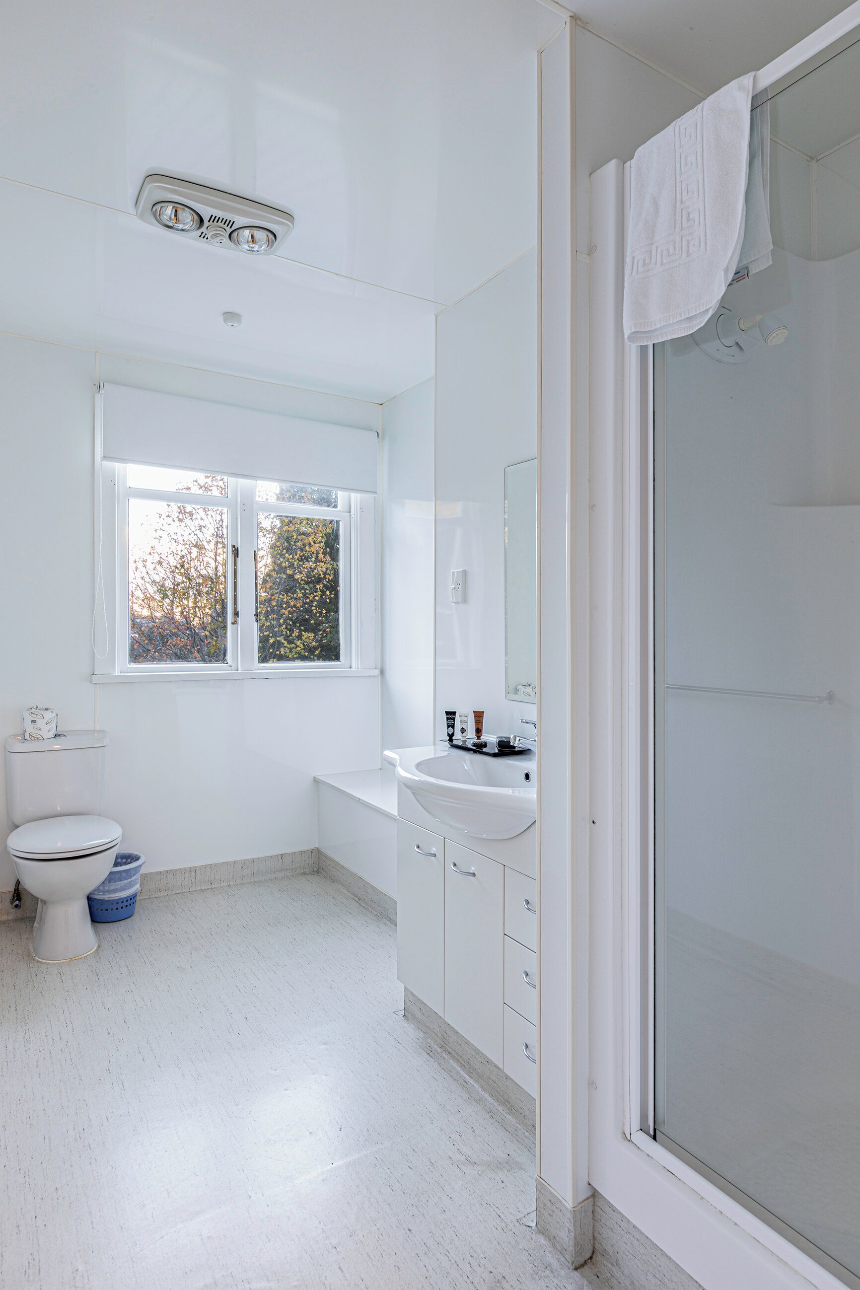 A modern bathroom with a toilet, sink, and shower.
