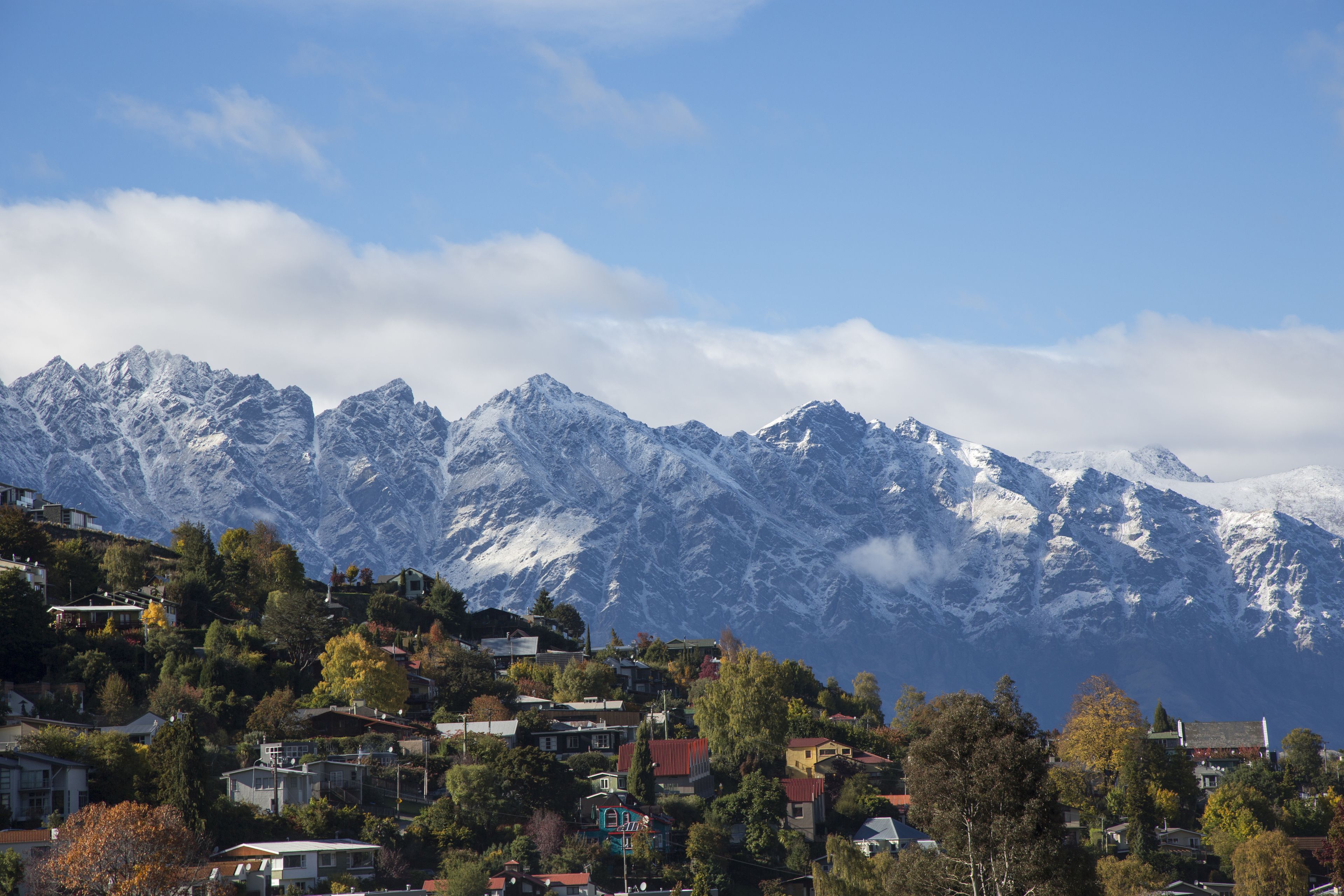 A mountainous landscape with snow-capped peaks and a town nestled at the base.
