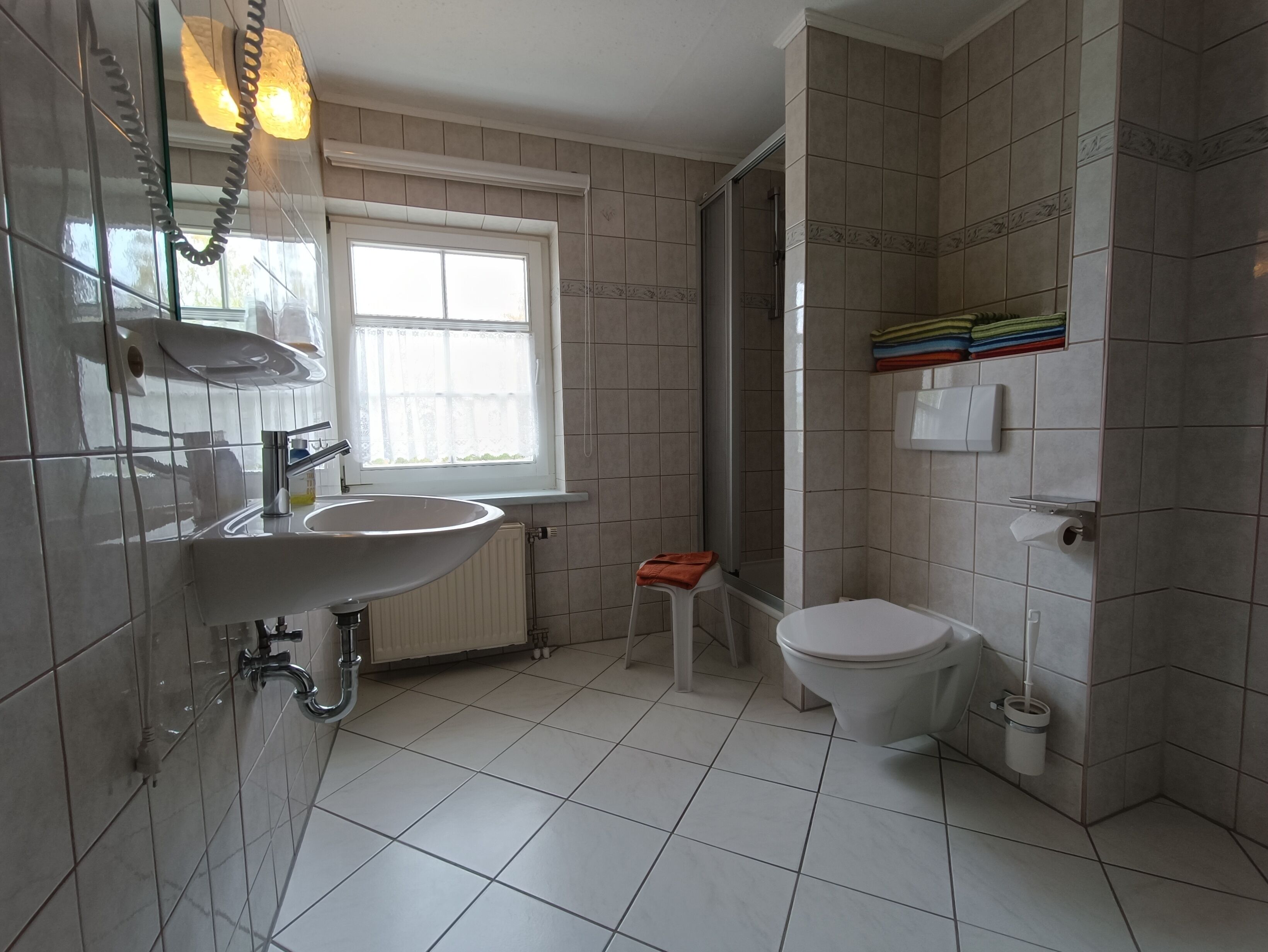 A modern bathroom with a large sink, toilet, and shower area.