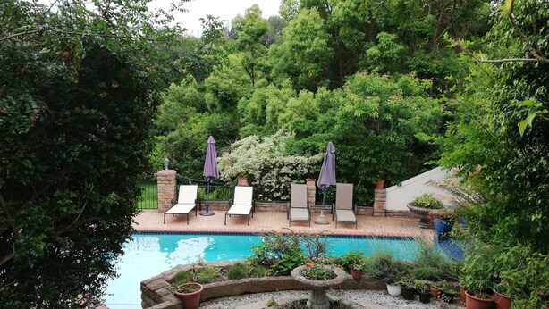 A pool area with lounge chairs and a stone fountain.