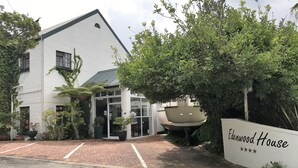 A white building with a sloped roof and a glass entrance. There is a sign that reads "Ladenwood House" with a five-star rating.