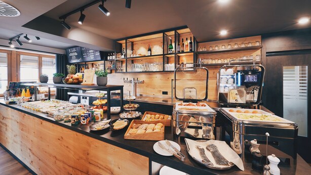 A buffet area with various food items, a coffee machine, and a menu board. - Hotel Hanauerhof (Appenweier)