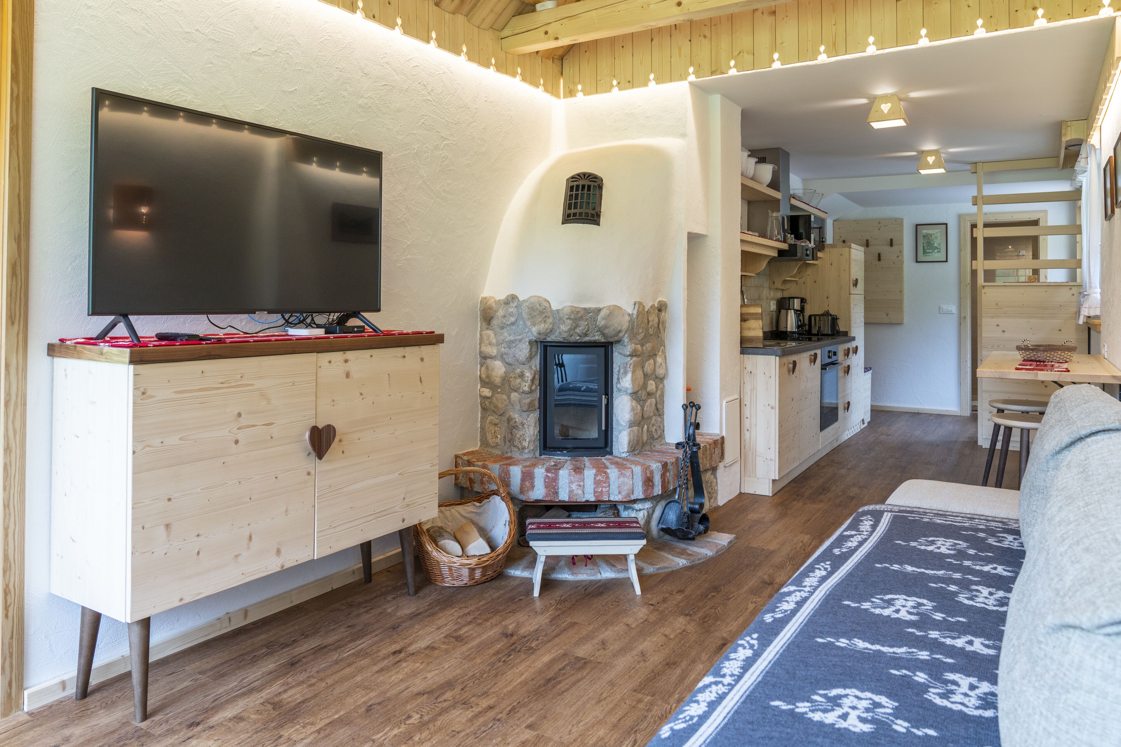 A cozy living room with a fireplace, wooden furniture, and a television.