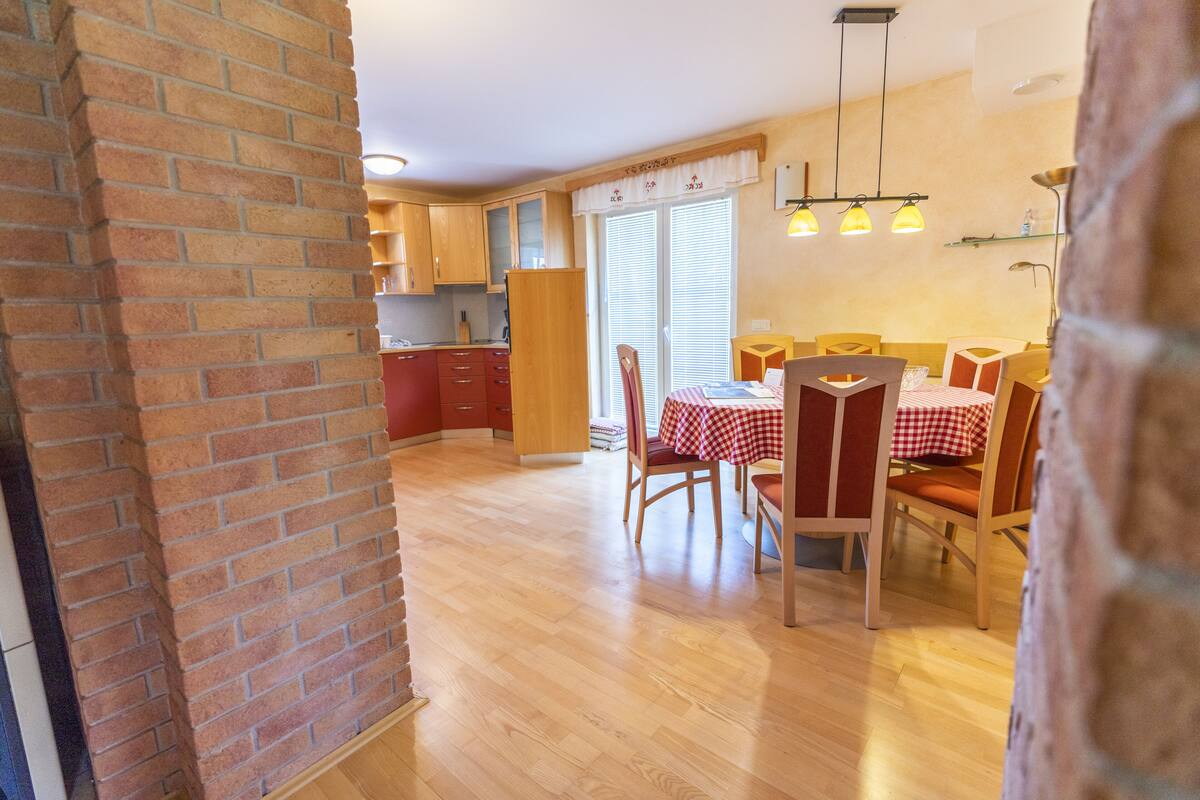 A spacious kitchen with wooden cabinets and a dining area with a table set for four.