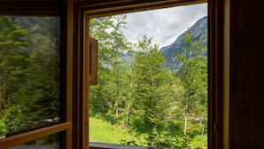 A wooden deck with a view of a forest and mountains. - ALPIK Chalets - Bohinj (Bohinj)