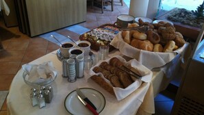 Een buffettafel met diverse etenswaren, zoals brood, gebak en toevoegingen.