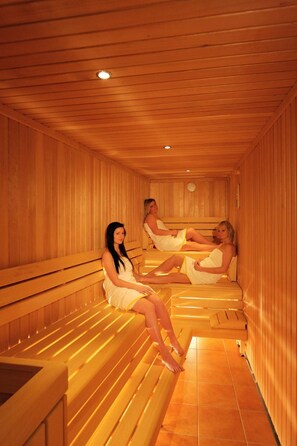 Een sauna met houten banken en een betegelde vloer.