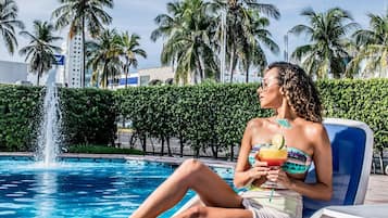 Una piscina al aire libre, sombrillas