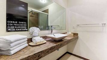 Un baño moderno con un espejo grande, un lavabo y un perchero para toallas.