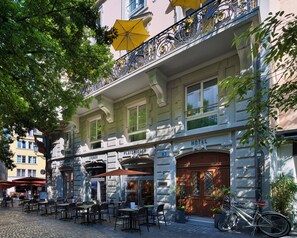 Un hôtel doté d’une terrasse, d’un vélo garé à l’extérieur et d’un balcon orné de ferronnerie.