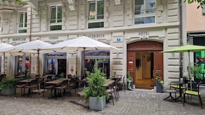 An outdoor seating area with tables and chairs, a bar, and a lounge. - PLATZHIRSCH ZÜRICH - Downtown Boutique Hotel & Sushi Lounge (Zürich)