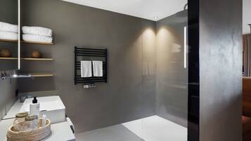 Een moderne badkamer met een grote spiegel, een wastafel en een douchecabine van glas.