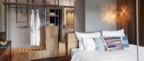 A modern bedroom with a large bed, wooden furniture, and a hanging light fixture.