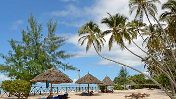On the beach, white sand, sun-loungers, beach umbrellas