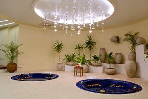 A spa area with two hot tubs, a wooden stool, and decorative vases. - Ocean Paradise Resort & Spa Zanzibar (Kiwengwa)