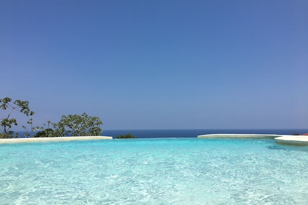 Een buitenzwembad en ligstoelen