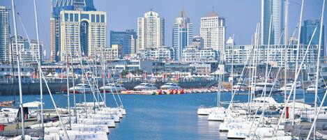A marina with numerous boats docked, surrounded by high-rise buildings.