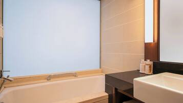 A modern bathroom with a bathtub, a sink, and a mirror.