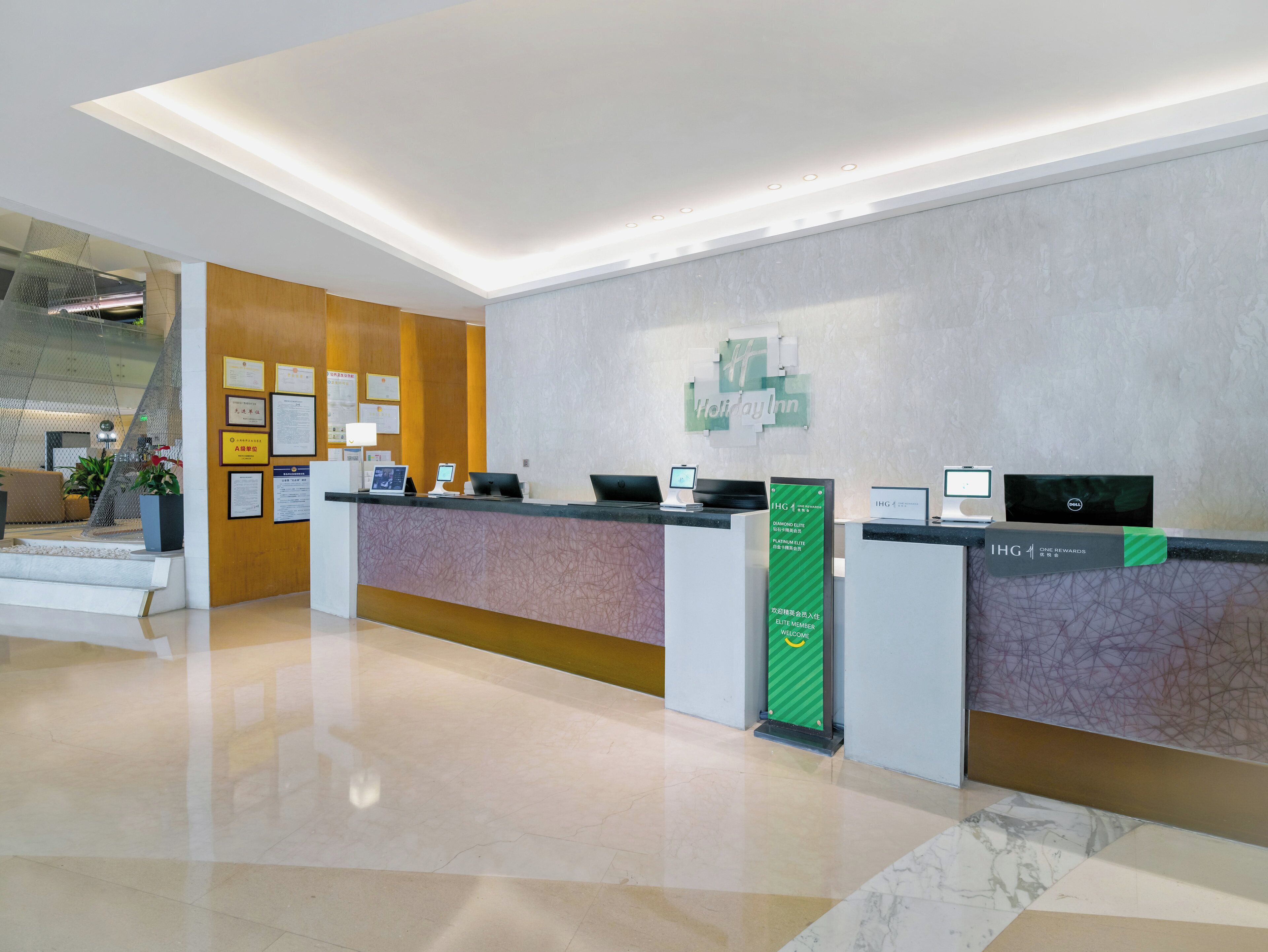 Ein Hotelrezeptionstresen mit modernem Design, einem digitalen Display und einem Schild für Holiday Inn Express.