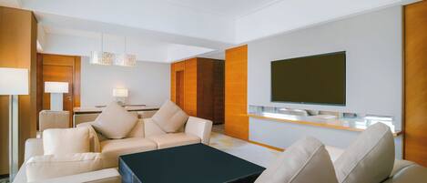Una sala moderna con un conjunto de sofá, una mesa de centro, un televisor montado en la pared y una pared de acento de madera.