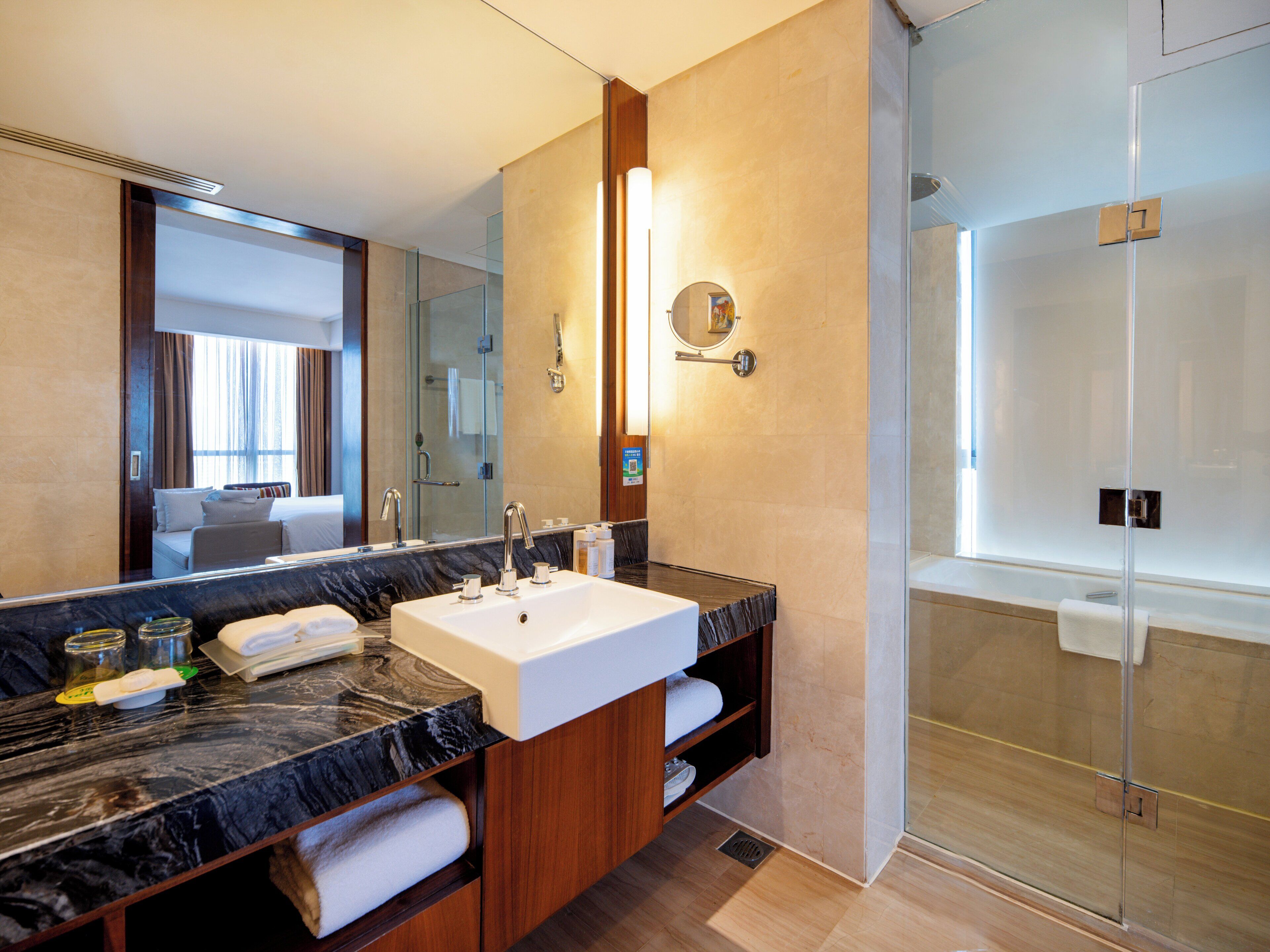 Un baño moderno con un espejo grande, dos lavamanos, una ducha y un mueble de tocador con encimera de mármol.