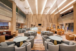 A spacious lobby with multiple seating areas, a bar, and a display case.