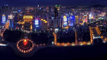 A cityscape at night with illuminated buildings and a circular park area.
