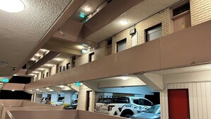 A multi-level parking garage with several cars parked, including a tow truck.