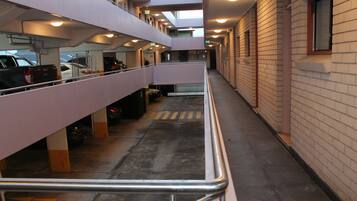 Een meerlaagse parkeergarage met een centrale doorgang en leuningen.