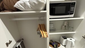 A compact kitchenette with a microwave, toaster, and coffee maker.