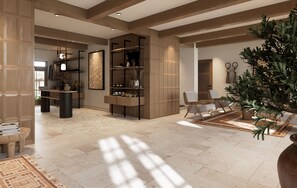 A spacious living area with a high ceiling, built-in wooden shelving, a large potted plant, and a seating area with a coffee table.