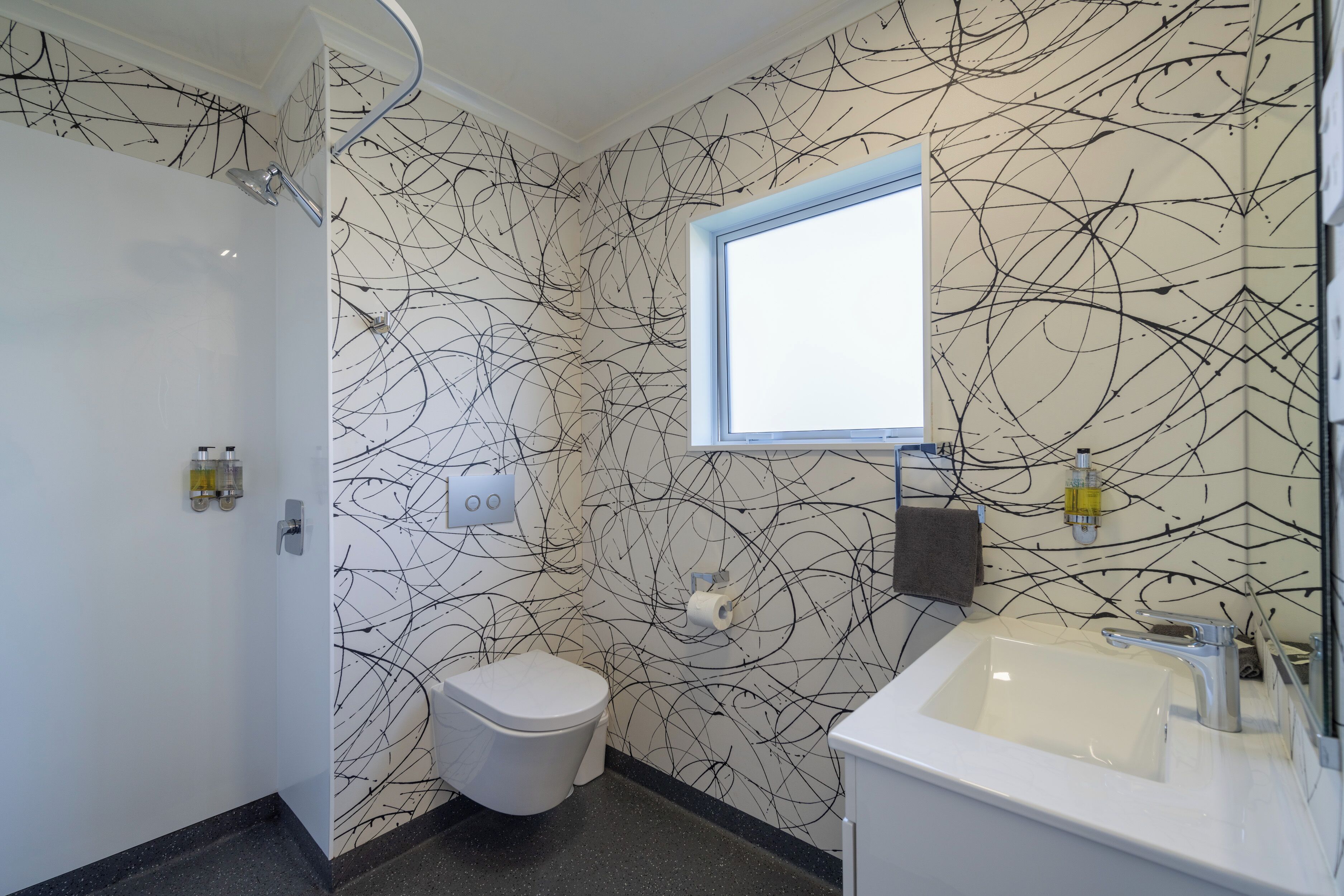A bathroom with a white toilet, a sink, and a window.