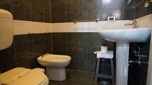 Un baño con inodoro, bidé y lavamanos.