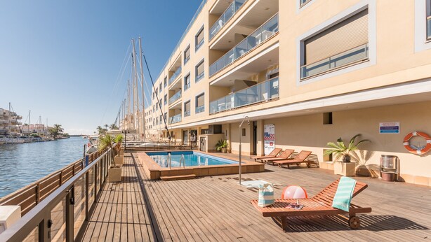 Ein Deck mit Pool, Liegestühlen und einem Rettungsring auf einem Kreuzfahrtschiff.