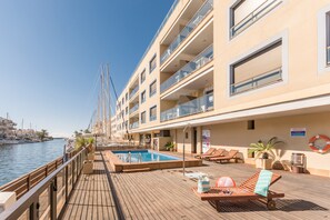 Un pont avec une piscine, des chaises longues et une bouée de sauvetage sur un navire de croisière.