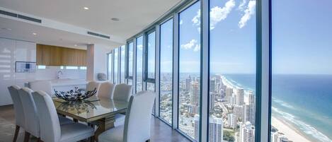 A modern kitchen with a large dining area and a panoramic ocean view.
