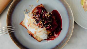 A dessert on a plate with whipped cream and berries.